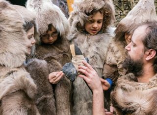 Children dressed as hunters in animal skins at Cheddar Gorge Museum